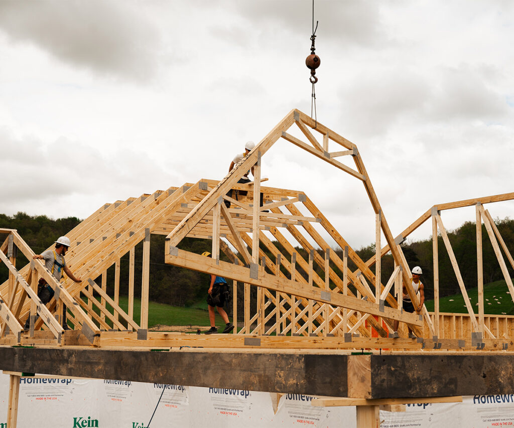 A truss being added to a new house with a crane